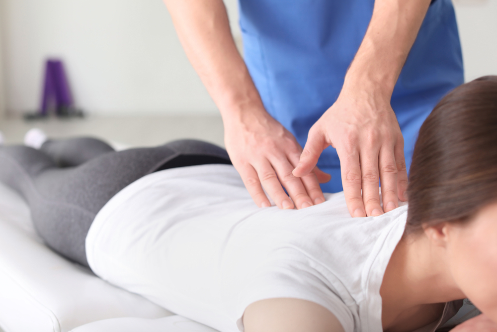 Woman receiving a massage on a treatment table in an office