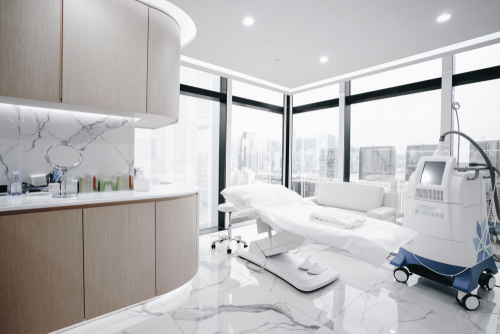 Professional clinic with wood medical cabinets and white exam table
