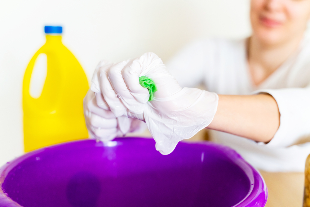 Person cleaning with a mix of bleach and water